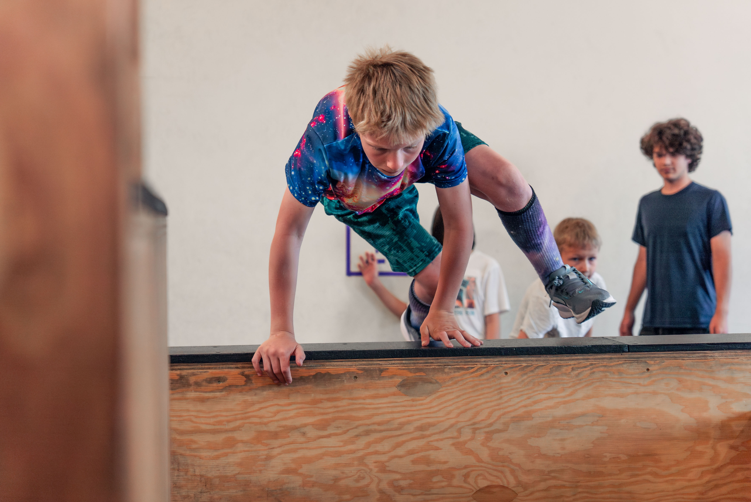 Student performing a step vault during a parkour class in Boulder